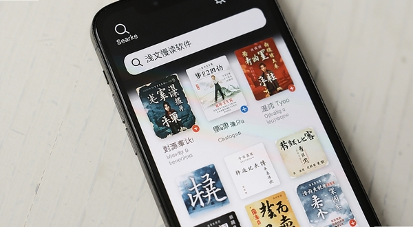 浅文慢读软件搜索界面特写,手机屏幕显示搜索框和多个书源结果列表,背景是简洁的浅色桌面,突出搜索图标和书籍封面