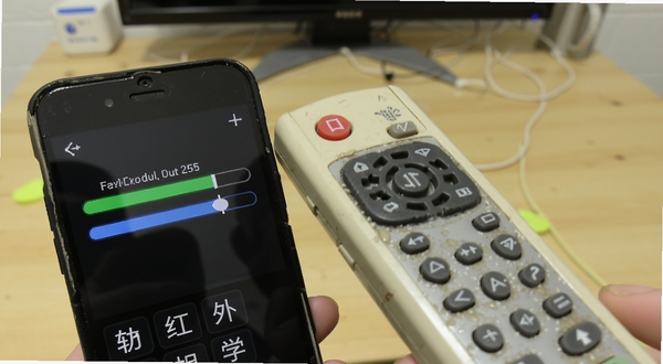 开空调遥控器软件红外学习功能界面,手机顶部红外发射口对准一个老式空调遥控器,屏幕显示学习进度条,背景是桌面环境,体现智能适配与学习的过程