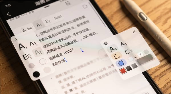 迦腾品宣文字编辑界面特写,画面主体为手机屏幕中正在编辑的文字块,光标闪烁,周围有字体大小与颜色选择浮窗,背景为木质桌面,旁边放着一支触控笔,整体色调温暖,细节清晰
