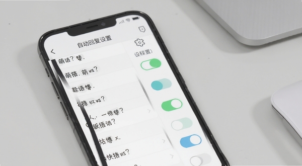 展示萌语快捷短语与自动回复设置界面,画面主体为手机屏幕显示短语列表和开关按钮,旁边有齿轮图标表示设置,背景区域为浅灰色办公桌面,整体风格简洁实用